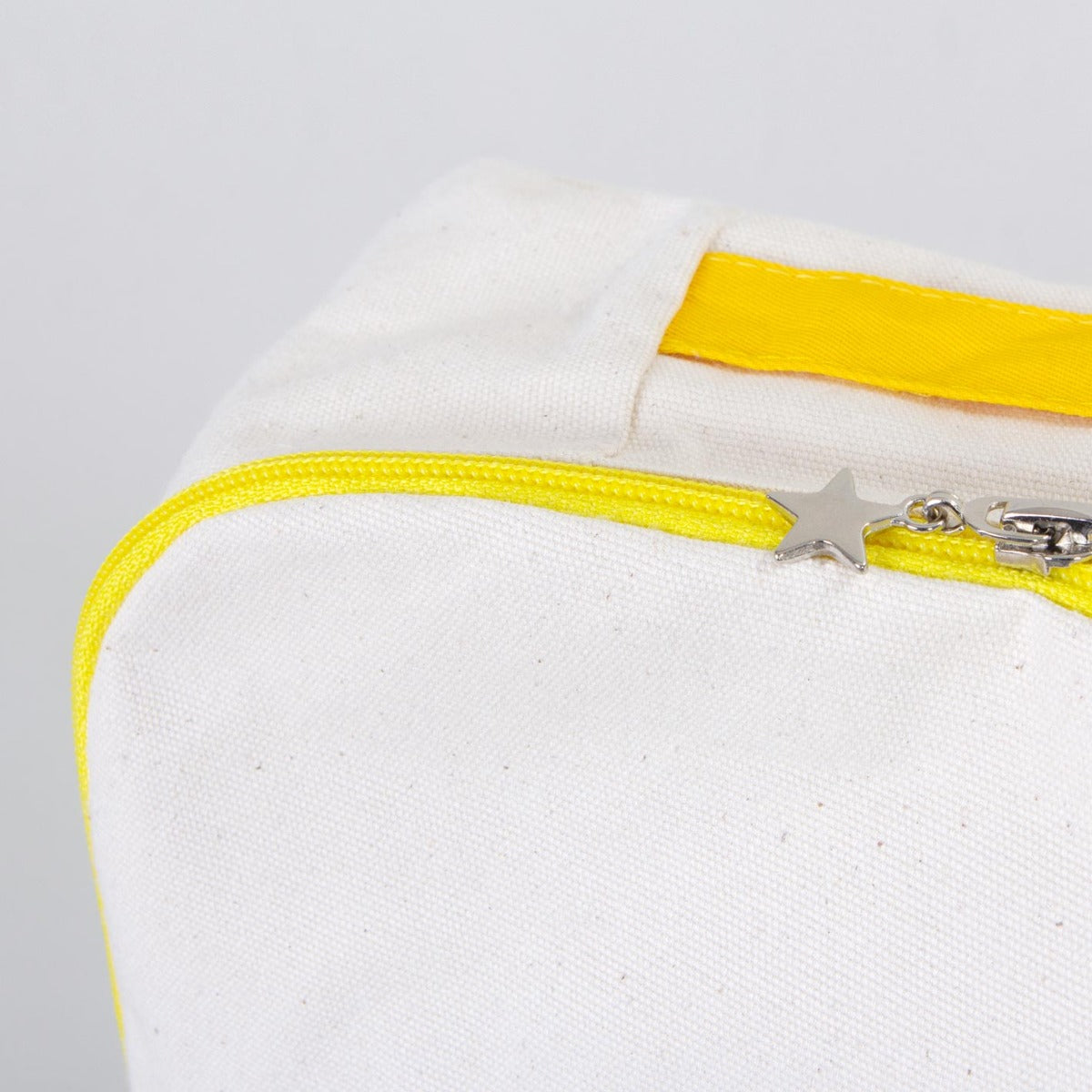 Ham renkli kumaştan, sarı fermuarlı ve ayarlanabilir askılı sırt çantası. Ön yüzünde karne günü temalı özelleştirilebilir 25×32×10 cm çanta.