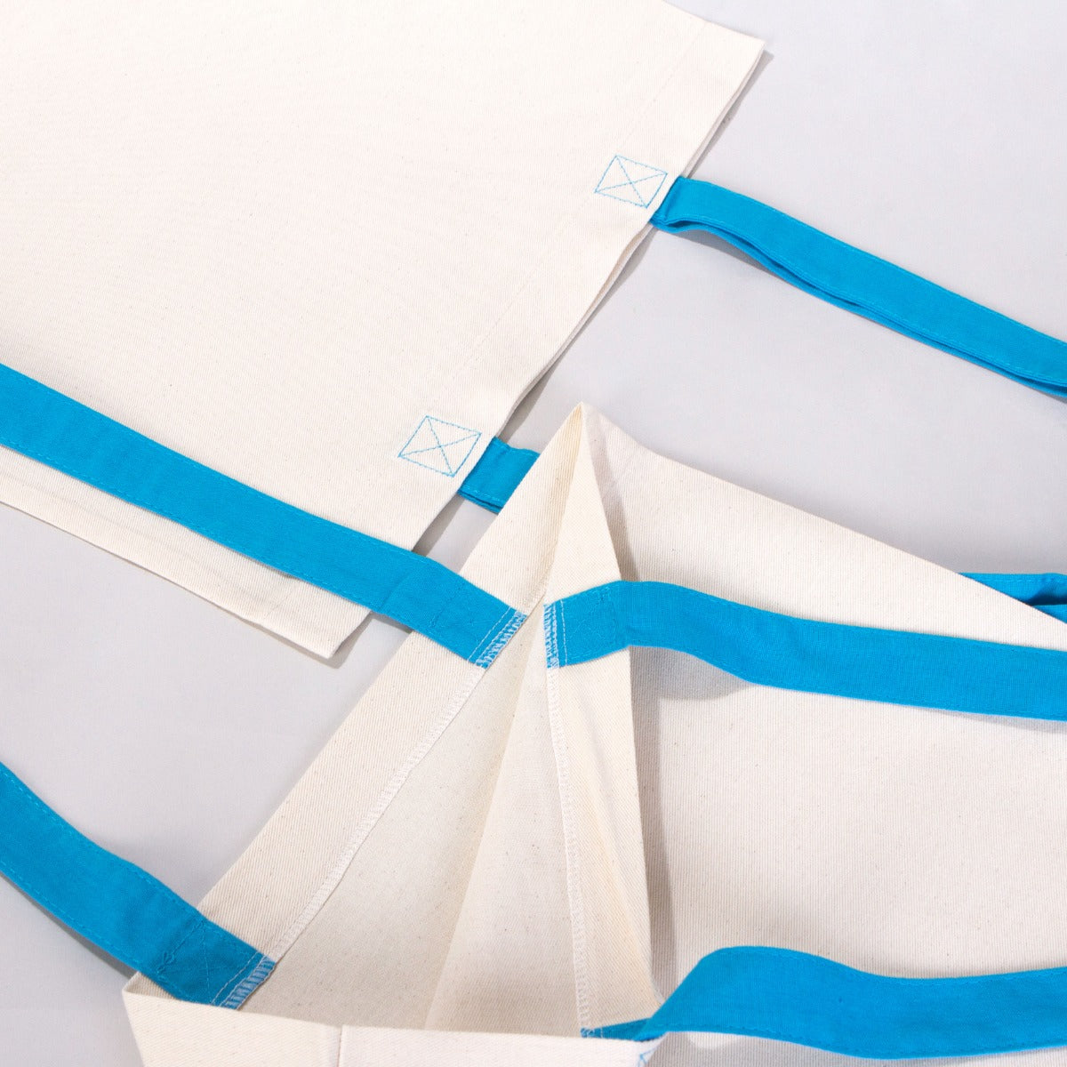 Karne Hediyesi baskılı, mavi saplı 40×35 cm bez tote çanta; dünya figürü, mezuniyet kepi, kitap ve balon desenli okul temalı çanta.