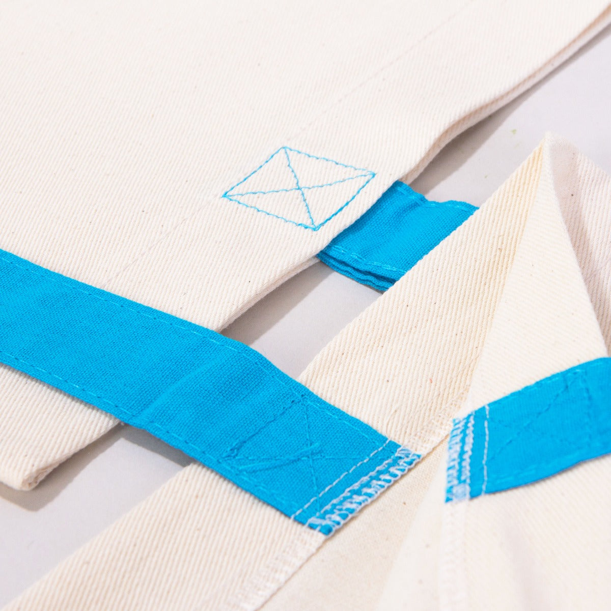 Karne Hediyesi baskılı, mavi saplı 40×35 cm bez tote çanta; dünya figürü, mezuniyet kepi, kitap ve balon desenli okul temalı çanta.