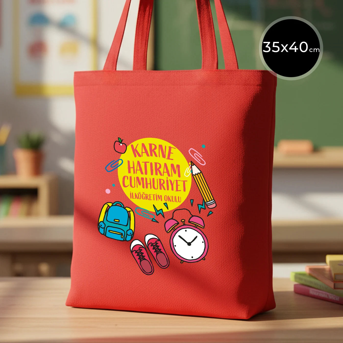 35×40 cm ebatlarında, kırmızı taşıma saplı kırmızı bez çanta. Ön yüzünde ürün grubuna ait 18 farklı karne temalı tasarımdan biri bulunur.