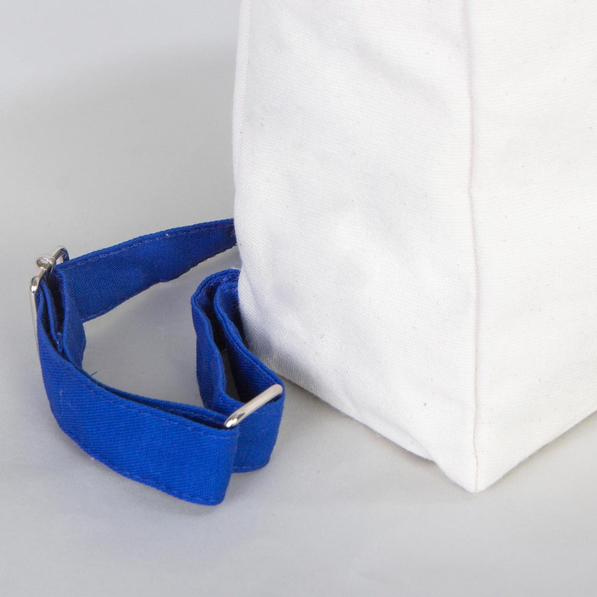 Natural renkte kumaştan yapılmış, mavi fermuarlı ve mavi askılı 25×32×10 cm çantanın ön yüzünde karne günü temalı modellerin yer aldığı renkli bir desenler bulunuyor.