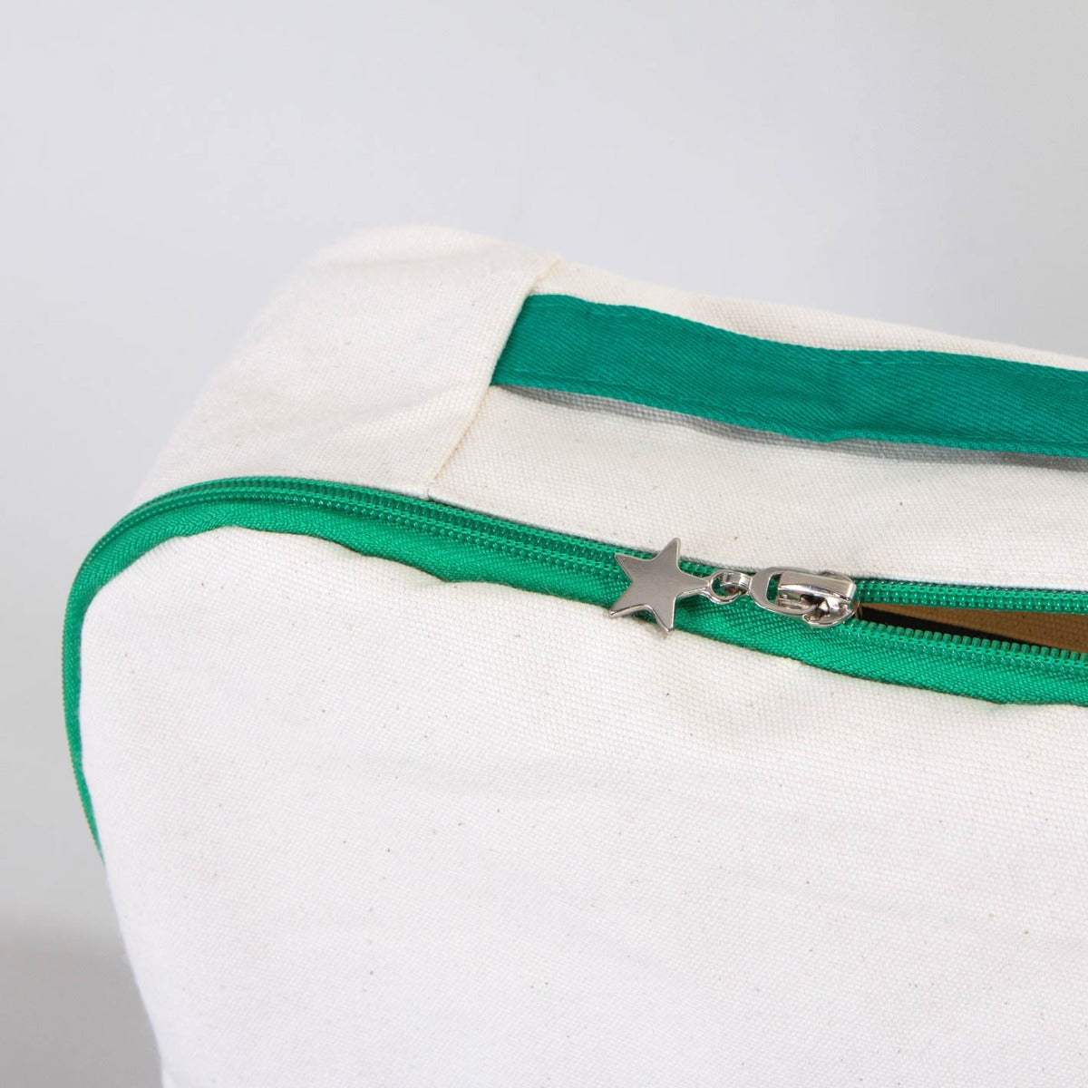 25×32×10 cm doğal renkli kumaştan okul sırt çantası, ön yüzünde karne temalı renkli baskı ve yeşil fermuar detayları bulunan model.