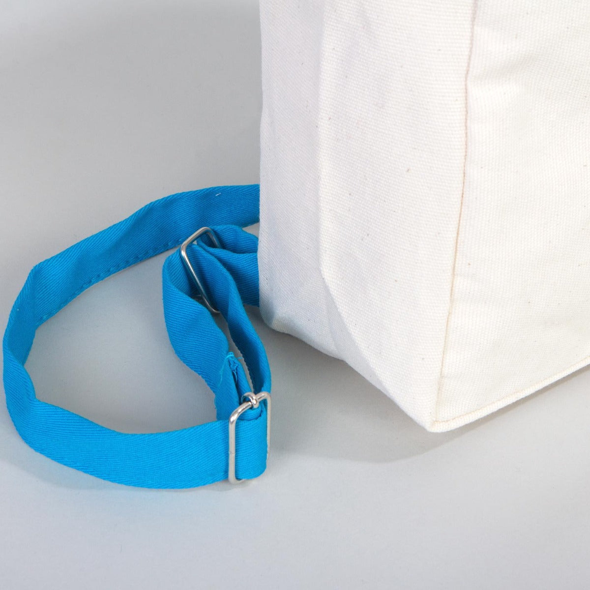 İyi Tatiller baskılı, turkuaz fermuarlı ve turkuaz askılı 25×32×10 cm bez sırt çantası; kitap ve balon desenli okul temalı çanta